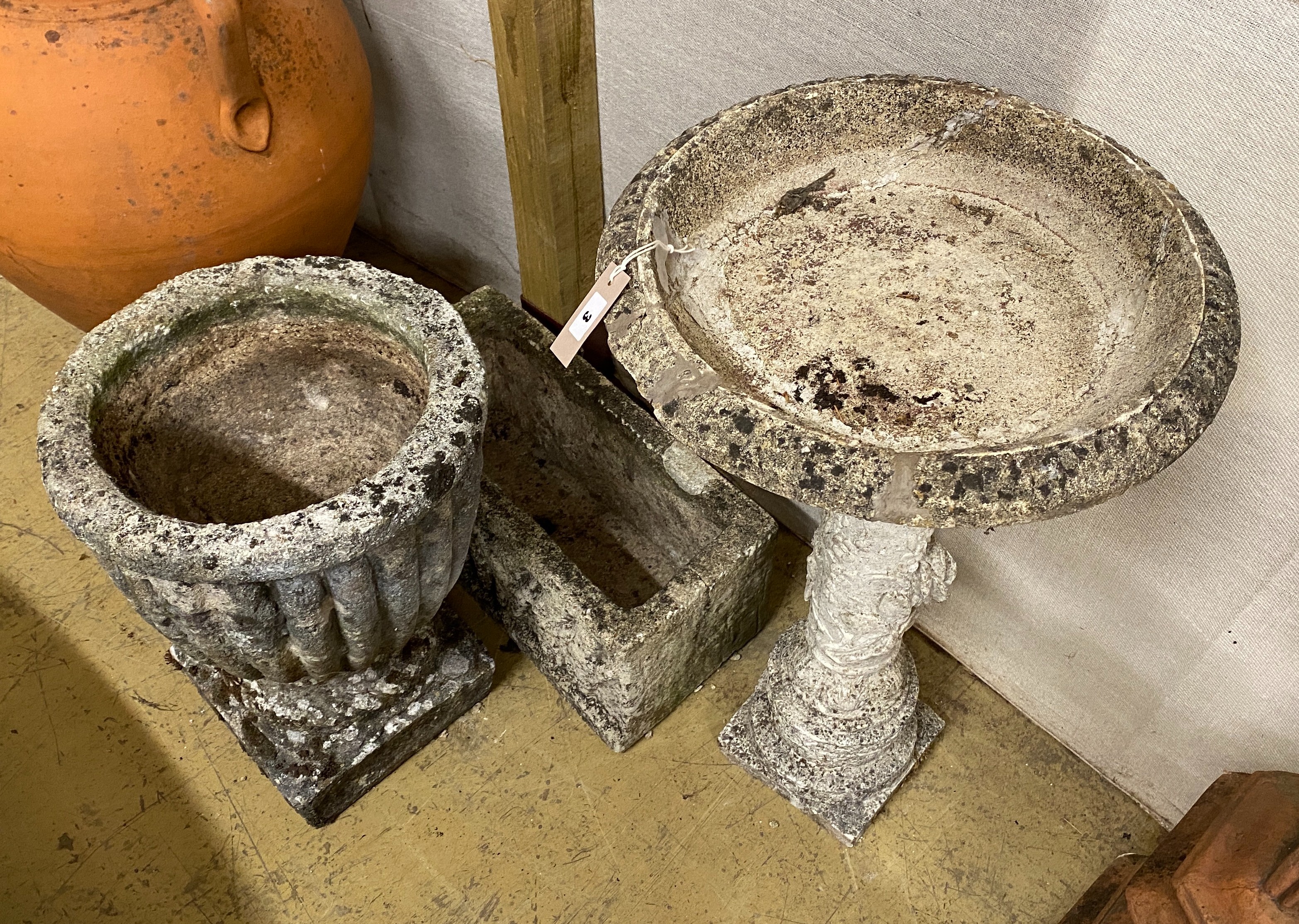 A reconstituted stone circular bird bath and two planters, largest 68cm